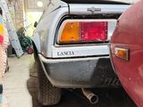 a car parked in a garage with a surfboard on the back of it