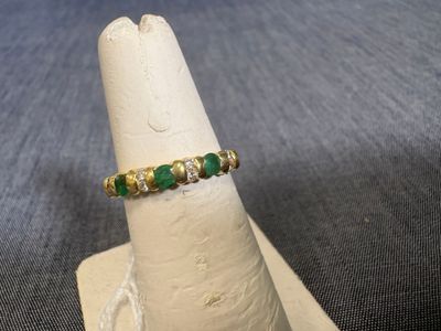 une image représentant une bague ornée de pierres vertes