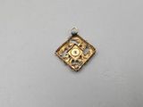 a gold plated pendant with a square design and a black bead