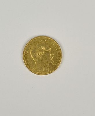 gros plan d'une pièce d'or sur une surface blanche