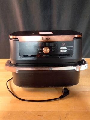 un micro-ondes noir et marron posé sur une table en bois