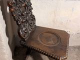 a wooden chair that is sitting in front of a wall