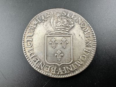 une pièce d'argent surmontée d'une couronne
