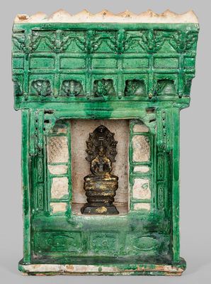 an image of a green and white fireplace with a statue in it