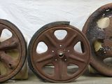 three old wheels are sitting on a table in front of a white cloth