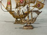 une maquette en or d'un voilier posée sur une table