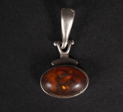 un pendentif en argent orné d'une grosse pierre d'ambre au centre