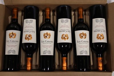 six bottles of wine in a cardboard box on a table