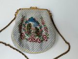 a small purse with a picture on it hanging on a chain