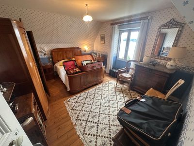 a bedroom with a bed, dresser, and a chair in it