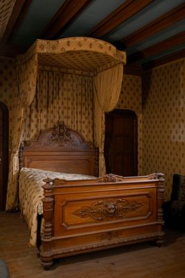 un lit à baldaquin dans une chambre avec du parquet