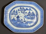 a blue and white plate with a picture of a village on it