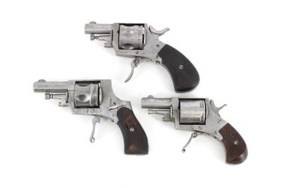 three revolvers with wooden grips on a white background