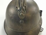 un casque métallique orné d'un oiseau sur un fond blanc
