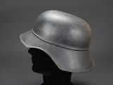 an old helmet on a mannequin head on a gray background
