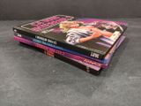 three books on a table with a black background and a black background
