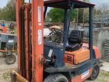un chariot élévateur qui est à l'arrêt dans l'herbe