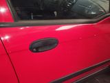 a close up of a red car with a black door handle