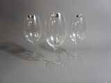 trois verres à vin vides posés sur une surface blanche
