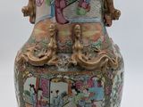 a vase with a painting on it sitting on a table