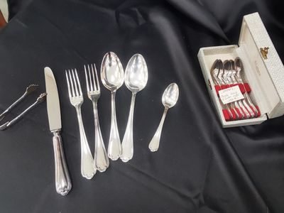 a box of silverware on a table with a knife, fork, spoon, and spoon rest