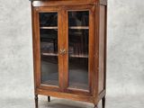 une vieille armoire en bois avec des portes vitrées et un plan de travail en marbre