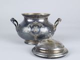 a silver vase with a lid sitting on a table