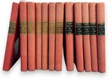 several red books are stacked on top of each other on a white surface