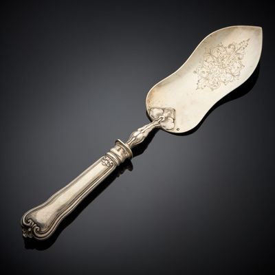 une cuillère en argent avec un manche, posée sur une surface noire