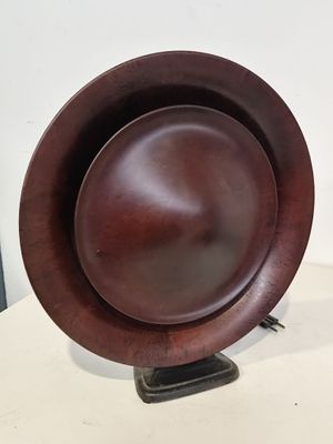 une assiette en bois posée sur un support, sur une table
