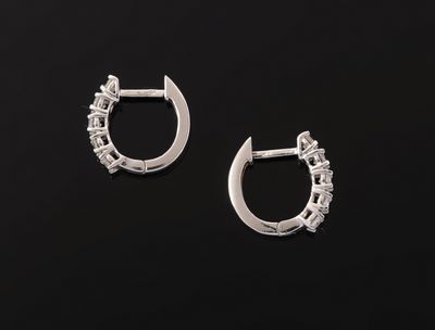 a pair of silver hoop earrings on a black background