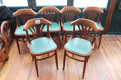 six chaises en bois avec des assises vertes dans une pièce