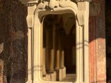 un miroir posé sur un pied devant un bâtiment