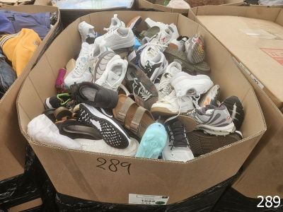plusieurs paires de chaussures dans une boîte posée sur le sol