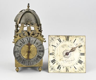 two clocks sitting next to each other on a white surface