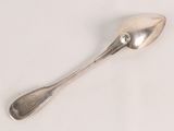 a spoon that is sitting on a white surface