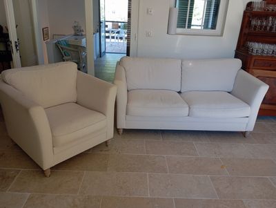 a white couch and a white chair in a living room