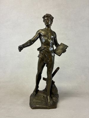bronze statue of a man holding a book and a sword