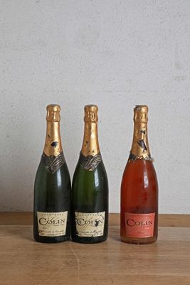 trois bouteilles de champagne posées sur une table l'une à côté de l'autre