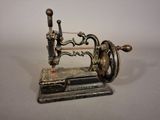 une petite machine à coudre ancienne exposée sur une table