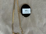 a gold necklace with a black and white pendant and a gold chain