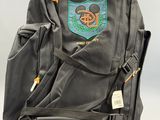 un sac à dos posé par terre, sur lequel est accrochée une étiquette
