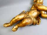 une statue en or représentant un bébé allongé par terre