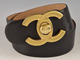 a close up of a black and gold belt with a gold buckle