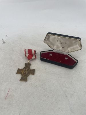 a small box with a medal and a red ribbon in it