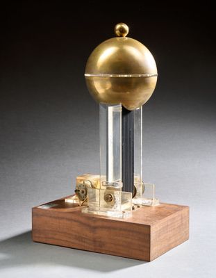 une image représentant un globe doré posé sur un socle en bois