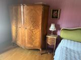 une chambre avec un lit, une commode et une lampe