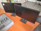 two monitors sitting on a desk next to a laptop