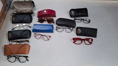 Plusieurs paires de lunettes sont disposées sur une surface blanche