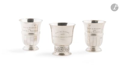 trois tasses en argent posées l'une à côté de l'autre sur une surface blanche